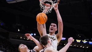 Purdue center Zach Edey (15) dunks over Davidson forward David Skogman, left, and forward Sean Logan in the first half of an NCAA college basketball game in Indianapolis, Saturday, Dec. 17, 2022. THE CANADIAN PRESS/AP-Michael Conroy