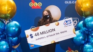 Juliette Lamour holds up a big cheque with her $48 million Lotto 649 prize money. (Handout /OLG)