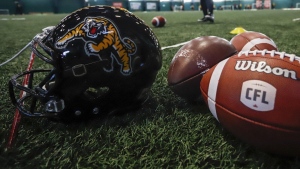 Balls and a helmet sit on the turf during Hamilton Tiger-Cats practice for the Grey Cup in Calgary, Wednesday, Nov. 20, 2019. The CFL has handed Hamilton Tiger-Cats offensive lineman Colin Kelly a two-game suspension for violating the league's drug policy.THE CANADIAN PRESS/Jeff McIntosh