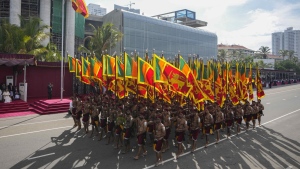 Sri Lankan government soldiers march carrying national flags during the 75th Independence Day ceremony in Colombo, Sri Lanka, Saturday, Feb. 4, 2023. Sri Lanka marks the anniversary of independence from British colonial rule on Feb. 4 each year. (AP Photo/Eranga Jayawardena)