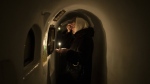A woman prays in front of a religious icon in the catacombs of the Pechersk Lavra monastery in Kyiv, Ukraine, Sunday, Feb. 5, 2023. (AP Photo/Daniel Cole)