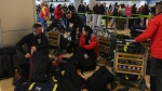 Spanish firefighters with their equipment at Barajas international airport, in Madrid, Spain, Monday, Feb. 6, 2023, before boarding a flight to help with a rescue mission in Turkey. A powerful quake has knocked down multiple buildings in southeast Turkey and Syria and many casualties are feared.(AP Photo/Paul White)