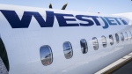 A WestJet planes waits at a gate at Calgary International Airport in Calgary, Alta., Wednesday, Aug. 31, 2022. THE CANADIAN PRESS/Jeff McIntosh