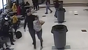 In this frame grab from surveillance video provided by the Kenosha Unified School District, an off-duty police officer escorts a 12-year-old student out of a school cafeteria following a lunchtime fight, in Kenosha, Wis., on March 4, 2022. An Illinois man has filed a federal lawsuit Monday, Feb. 6, 2023, alleging that an off-duty police officer improperly restrained his 12-year-old daughter during a fight in a Wisconsin middle school last year by placing his knee on her neck, similar to how Derek Chauvin fatally restrained George Floyd. (Kenosha Unified School District via AP, File)
