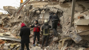 Rescue workers search for survivors on a collapsed building in Malatya, Turkiye, Tuesday, Feb. 7, 2023. Search teams and aid are pouring into Turkiye and Syria as rescuers working in freezing temperatures dig through the remains of buildings flattened by a magnitude 7.8 earthquake. (AP Photo/Emrah Gurel)