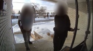 Two intruders are shown outside a Toronto home. The homeowner says that the pair barged in after his 13-year-old son, who was home alone at the time, answered the door.