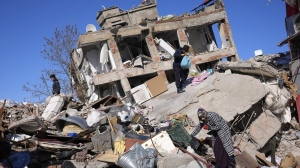 People search for their belongings at a collapsed building in Kahramanmaras, southern Turkiye, Wednesday, Feb. 8, 2023.An Ontario man says his Canadian parents are stuck in a village after the deadly earthquakes killed over 11,000 southeast of Turkey and parts of neighboring Syria. THE CANADIAN PRESS/AP/Hussein Malla