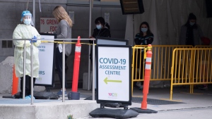 FILE - A nurse stands outside the COVID-19 testing centre at Women’s College Hospital in Toronto on Friday, April 9, 2021. THE CANADIAN PRESS/Frank Gunn 