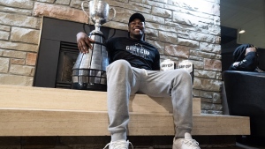 Henoc Muamba of the Toronto Argonauts holds the Grey Cup after arriving at Toronto Pearson International Airport in Mississauga, Ont., Monday, Nov. 21, 2022. Muamba will help the Toronto Argonauts defend their Grey Cup title. THE CANADIAN PRESS/Arlyn McAdorey