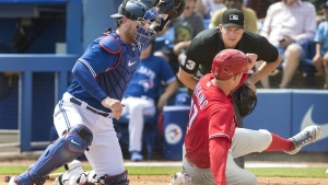 Philadelphia Phillies' Rhys Hoskins is out at home plate with the tag by Toronto Blue Jays catcher Danny Jansen in the first inning of their spring training game in Dunedin, Fla., Sunday, March 5, 2023. THE CANADIAN PRESS/Fred Thornhill