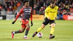 Toronto FC forward Deandre Kerr (29) dribbles the ball through the legs of Columbus Crew defender Milos Degenek (5) and goes onto score during first half MLS soccer action, in Toronto, on Saturday, March 11, 2023.THE CANADIAN PRESS/Christopher Katsarov 