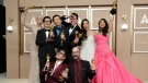 Jamie Lee Curtis, from back left, Ke Huy Quan, James Hong, Jonathan Wang, Michelle Yeoh, and Stephanie Hsu, Daniel Kwan, left front, and Daniel Scheinert, winners of the award for best film for "Everything Everywhere All at Once," pose in the press room at the Oscars on Sunday, March 12, 2023, at the Dolby Theatre in Los Angeles. (Photo by Jordan Strauss/Invision/AP) 