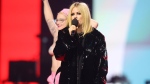Avril Lavigne presents as a topless protester rushes the stage during the Junos Monday, March 13, 2023. Police say charges are pending after a topless protester interrupted the Juno Awards. THE CANADIAN PRESS/Timothy Matwey
