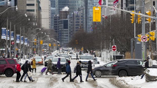 Pedestrians cross a street in Toronto