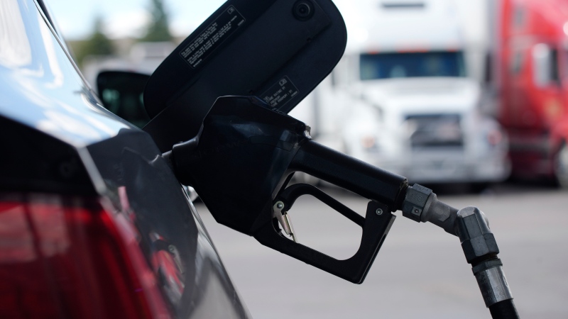 A pump handle hangs from a car at a gas station as motorists take to the road to start the Memorial Day weekend, Thursday, May 27, 2021, near Cheyenne, Wyo. (AP Photo/David Zalubowski) 