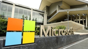 FILE - In this July 3, 2014, file photo, the Microsoft Corp. logo is displayed outside the Microsoft Visitor Center in Redmond, Wash. Microsoft is infusing generative AI tools into its Office software, including Word, Excel and Outlook emails. The company said Thursday, March 16, 2023 the new feature, named Copilot, is a processing engine that will allow users to do things like summarize long emails, draft stories in Word and animate slides in PowerPoint. (AP Photo/Ted S. Warren, File)