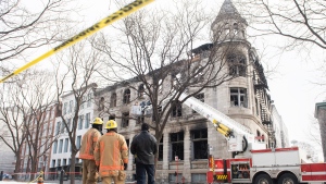 Investigators and firefighters survey the scene following a fire in Old Montreal, Sunday, March 19, 2023, that gutted a heritage building. Several people are still unaccounted for. THE CANADIAN PRESS/Graham Hughes 