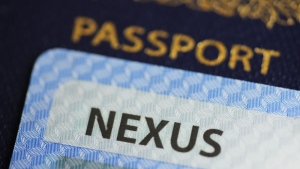 A NEXUS card and a Canadian passport are pictured in Ottawa on Tuesday, Jan. 17, 2023. The federal government says the Nexus trusted-traveller program will fully ramp back up within five weeks, allowing frequent border crossers to complete their applications and speed up their trips. THE CANADIAN PRESS/Sean Kilpatrick