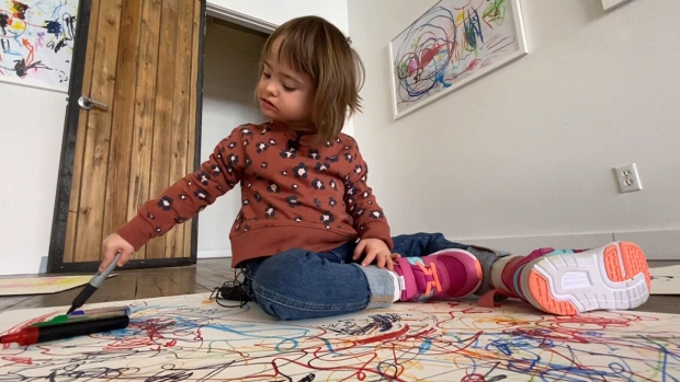Five-year-old Olly Sardelic is seen amongst her drawings in Toronto on March 21, 2023. 