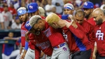 Puerto Rico pitcher Edwin Diaz (39) is being helped by team pitching coach Ricky Bones and medical staff after the the Pool D game against Dominican Republic at the World Baseball Classic at loanDepot Park on Wednesday, March 15, 2023, in Miami. (David Santiago/Miami Herald via AP)