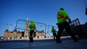 Work crews set up security fencing on Parliament Hill in Ottawa on Wednesday, March 22, 2023, in preparation for U.S. President Joe Biden’s visit. THE CANADIAN PRESS/Sean Kilpatrick