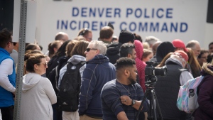Parents wait for students to be walked out after two administrators shot and wounded after a handgun was found during a daily search of a student at Denver East High School Wednesday, March 22, 2023, in Denver. (AP Photo/David Zalubowski)