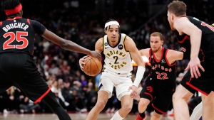 Indiana Pacers guard Andrew Nembhard (2) drives between Toronto Raptors forward Chris Boucher (25), guard Malachi Flynn (22) and centre Jakob Poeltl (19) during second half NBA basketball action in Toronto on Wednesday, March 22, 2023. THE CANADIAN PRESS/Frank Gunn