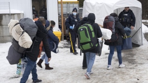A family of asylum seekers from Colombia is met by RCMP officers after crossing the border at Roxham Road into Canada Thursday, February 9, 2023 in Champlain, New York. Canada and the United States are on the cusp of agreeing to designate all 8,900 km of their shared border as an official crossing under the Safe Third Country Agreement.THE CANADIAN PRESS/Ryan Remiorz