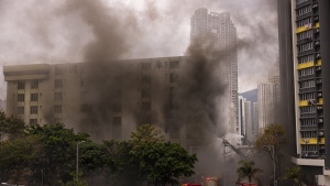 Firefighters battle a fire in Cheung Sha Wan, a residential and industrial area, in Hong Kong, Friday, March 24, 2023. (AP Photo/Louise Delmotte)