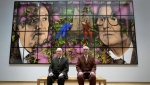 Gilbert and George sit with their artwork called On The Bench in their exhibition called The Paradisical Pictures at the opening of The Gilbert & George Centre in east London, Friday, March 24, 2023. (AP Photo/Kirsty Wigglesworth)