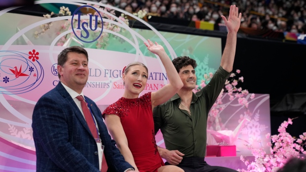Piper Gilles, center, and Paul Poirier, right, of Canada react to audience members after getting their score for their performance in the ice dance free dance program in the World Figure Skating Championships in Saitama, north of Tokyo, Saturday, March 25, 2023. (AP Photo/Hiro Komae)
