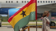 U.S. Vice President Kamala Harris smiles as she walks past a flag of Ghana upon her arrival in Accra, Ghana, Sunday March 26, 2023. Harris is on a seven-day African visit that will also take her to Tanzania and Zambia. (AP Photo/Misper Apawu)