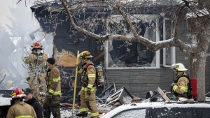 Firefighters attend the scene of a house explosion that injured several people, destroyed one home and damaged others in Calgary, Monday, March 27, 2023. THE CANADIAN PRESS/Jeff McIntosh