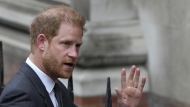 Britain's Prince Harry waves to the media as he arrives at the Royal Courts Of Justice in London, Tuesday, March 28, 2023. (AP Photo/Alastair Grant)