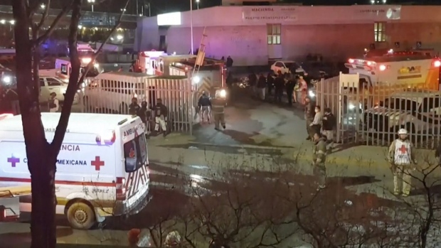 Image taken from a video showing ambulances and rescue teams staffers outside an immigration center in Ciudad Juarez, Mexico, Tuesday, March 28, 2023. (AP Photo)
