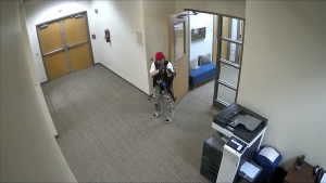In this screen grab from surveillance video tweeted by the Metropolitan Nashville Police Department, Audrey Elizabeth Hale points an assault-style weapon inside The Covenant School in Nashville, Tenn., Monday, March 27, 2023. The former student shot through the doors of the Christian elementary school and killed several children and adults before being killed by police. (Courtesy of Metropolitan Nashville Police Department via AP)