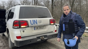 In this photo provided by the IAEA Press Office, U.N. atomic energy chief Rafael Mariano Grossi stands on a road next to a UN vehicle on his way to the Zaporizhzhia Nuclear Power Plant, in southeastern Ukraine, Wednesday March 29, 2023. (IAEA Press Office via AP)