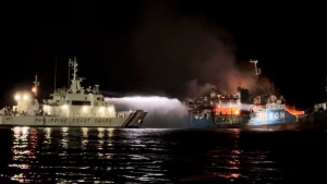 In this photo provided by the Philippine Coast Guard, a Philippine Coast Guard ship trains its hose as it tries to extinguish fire on the MV Lady Mary Joy at Basilan, southern Philippines early Thursday March 30, 2023. Multiple people died and others were missing after an inter-island cargo and passenger ferry with more than 200 passengers and crew onboard caught fire close to midnight in the southern Philippines, a provincial governor said Thursday. (Philippine Coast Guard via AP)