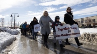 People march from the RCMP headquarters to the Kwanlin Dun Cultural Centre to raise awareness of the Yukon overdose crisis in Whitehorse on Wednesday, March 22, 2023. First Nations from around the territory held marches and lit sacred fires following the First Nation of Nacho Nyak Dun's state of emergency declaration over the opioid crisis and two murders in the community. THE CANADIAN PRESS/Crystal Schick