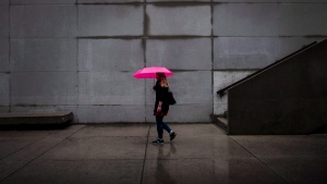 People with umbrellas walk through city hall in Toronto, on Tuesday, September 25, 2018. THE CANADIAN PRESS/Christopher Katsarov 