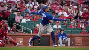 Toronto Blue Jays' George Springer follows through on an RBI single during the ninth inning of an opening day baseball game on Thursday, March 30, 2023, in St. Louis. (AP Photo/Jeff Roberson)