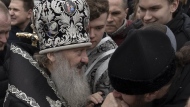 A senior priest of the Ukrainian Orthodox Church blesses parishioners in the Kyiv Pechersk Lavra monastery complex in Kyiv, Ukraine, Wednesday, March 29, 2023. The Russian invasion of Ukraine is reverberating in a struggle for control of a monastery complex. The government says it's evicting the Ukrainian Orthodox Church from the complex as of March 29, accusing it of pro-Russia actions and ideology. (AP Photo/Andrew Kravchenko)