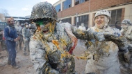 Revellers dressed in mock military garb take part in "Els Enfarinats" food-battle in the southeastern Spanish town of Ibi in December 2022, a celebration very similar to April Fools' Day. (Jaime Reina/AFP/Getty Images via CNN)