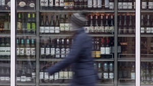 A person walks past shelves of bottles of alcohol on display at an LCBO in Ottawa, Thursday March 19, 2020. Researchers behind the latest guidance on drinking alcohol are calling on Health Canada to update its website with their findings to avoid confusion about safe levels of consumption.THE CANADIAN PRESS/Adrian Wyld