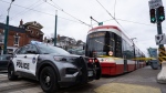 Police cars surround a TTC streetcar on Spadina Ave., in Toronto on Tuesday, January 24, 2023 after a stabbing incident. THE CANADIAN PRESS/Arlyn McAdorey