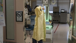 A health-care worker dons a gown as they prepare to see a patient in the intensive care unit at Hospital for Sick Children in Toronto on Wednesday, Nov. 30, 2022. Health Canada has approved a new antibody drug to help protect babies from serious illness caused by respiratory syncytial virus, or RSV. THE CANADIAN PRESS/Chris Young