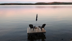 Muskoka chairs sit on a dock looking over Boshkung Lake, in Algonquin Highlands, Ont., Monday, Oct. 5, 2020. As cottage season dawns, the prospect of joint ownership with family or friends grows anew for many Canadians, budding perennially like a lakeside plant. THE CANADIAN PRESS/Giordano Ciampini