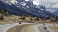 Traffic travels along the Trans Canada Highway past Mount Rundle of the Rocky Mountains near Canmore, Alta., on April 24, 2023. THE CANADIAN PRESS/Jeff McIntosh