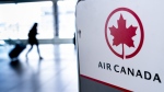 Air Canada says it is experiencing technical problems causing flight delays for the second time in a week. A lone passenger walks past the Air Canada check-in counter at Montreal-Trudeau International Airport in Montreal, on Wednesday, April 8, 2020. THE CANADIAN PRESS/Paul Chiasson
