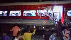 People inspect the site of passenger trains that derailed in Balasore district, in the eastern Indian state of Orissa, Friday, June 2, 2023. Two passenger trains derailed in India, killing at least 13 people and trapping hundreds of others inside more than a dozen damaged coaches, officials said. About 400 people were injured and taken to hospitals, and the cause of the accident was under investigation, officials said. (Press Trust of India via AP)